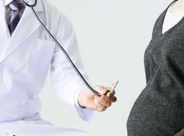 聴診器を妊婦に当てる医師